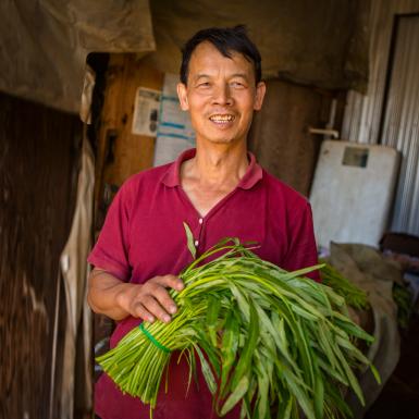 A Chinese farmer holds produce.