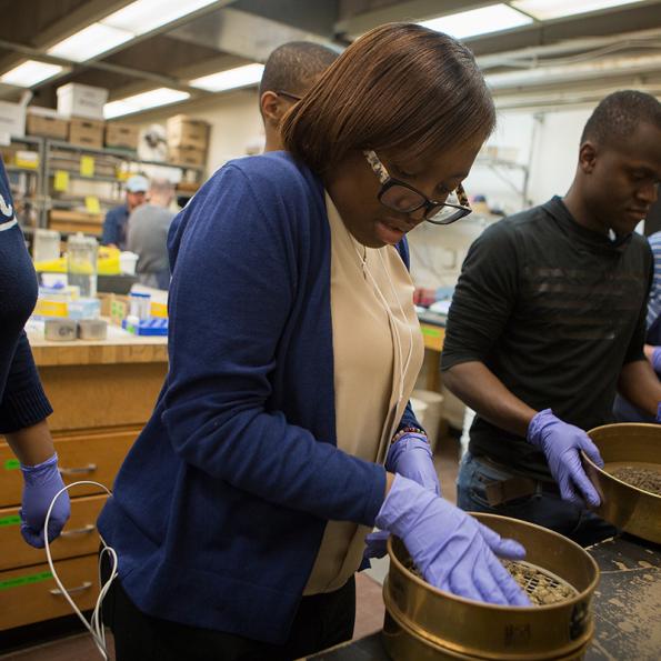 Students sieve soil in the Cornell Soil Health Lab