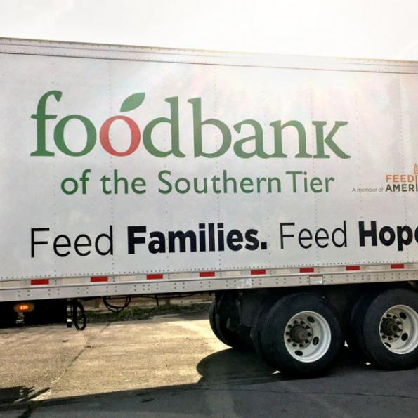 A food truck with writing on the back sits idle as it waits to be unloaded